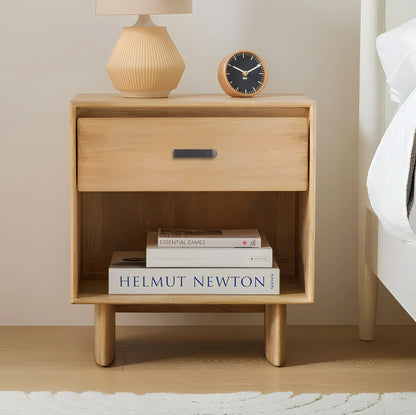 Wooden nightstand with a sleek handle, styled with books and a lamp against a neutral background—by Mantara.