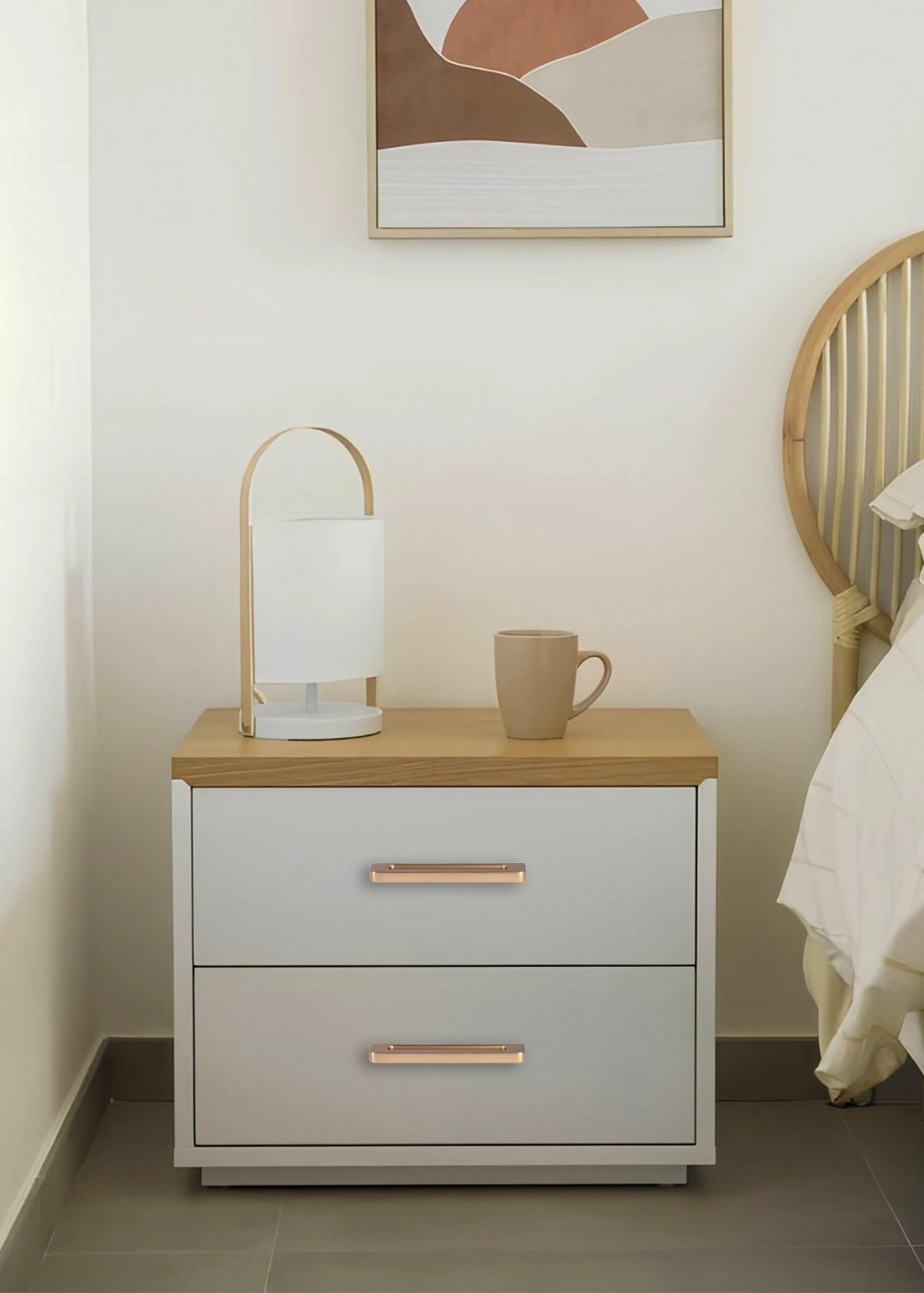 White nightstand with a wooden top and gold handles, styled in a cozy bedroom setting—elegant contrast by Mantara.