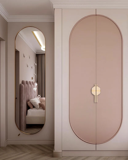Pink wardrobe with sleek handles and mirror reflection, styled in a cozy bedroom setting with soft tones—by Mantara.