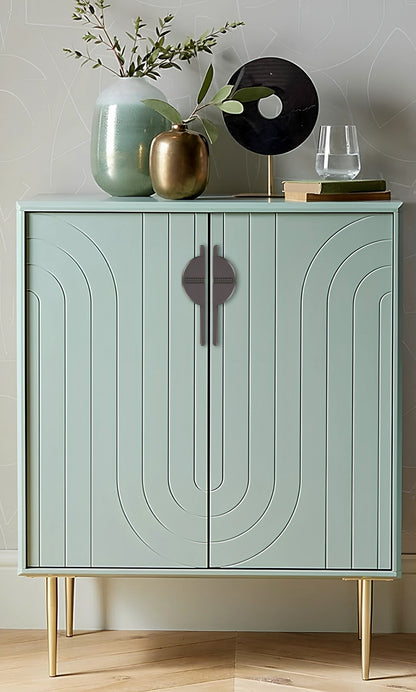 Light green cabinet with sleek handles, styled with decorative items against a light gray wall background—by Mantara.