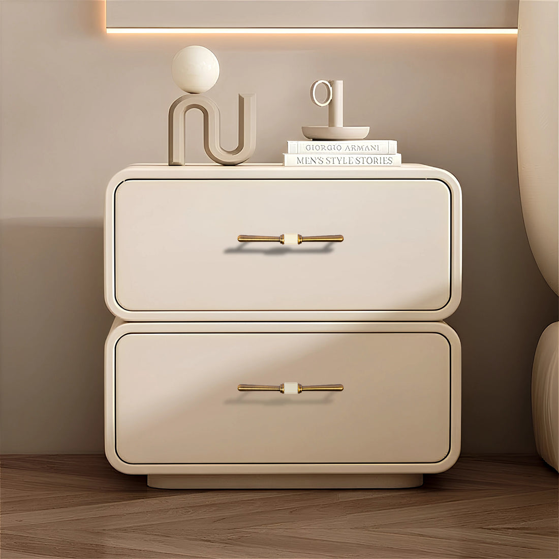 Beige nightstand with two drawers and Bronze handles, styled with decorative items on a wooden floor—by Mantara.
