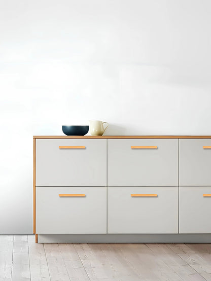 Modern dresser with light gray drawers, wooden top, and subtle handle, set against a clean white background—by Mantara.