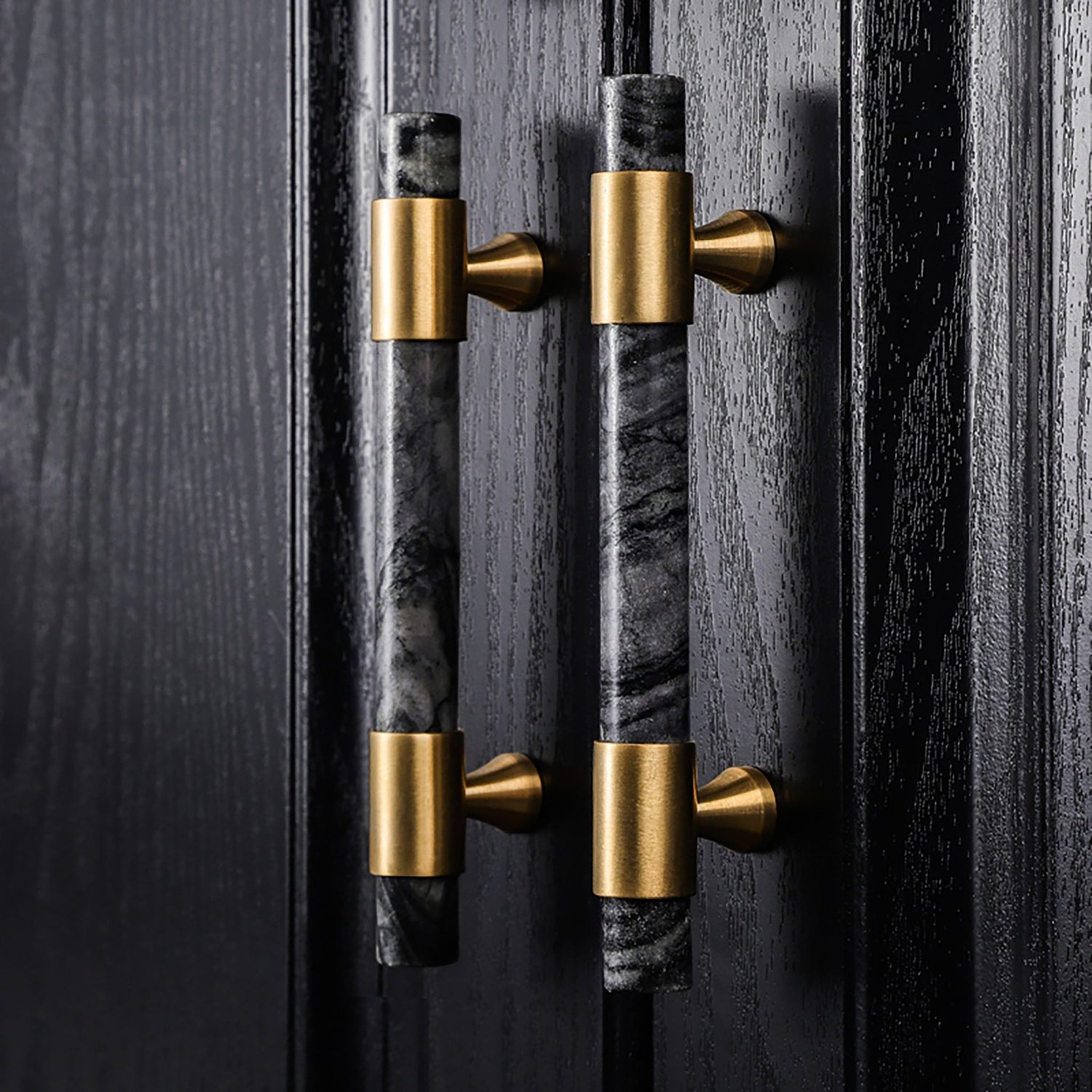 Decorative door handles with marble and gold finish on a dark wooden door, designed by Mantara