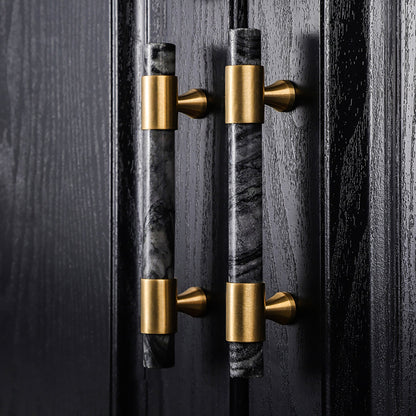 Decorative door handles with marble and gold finish on a dark wooden door, designed by Mantara