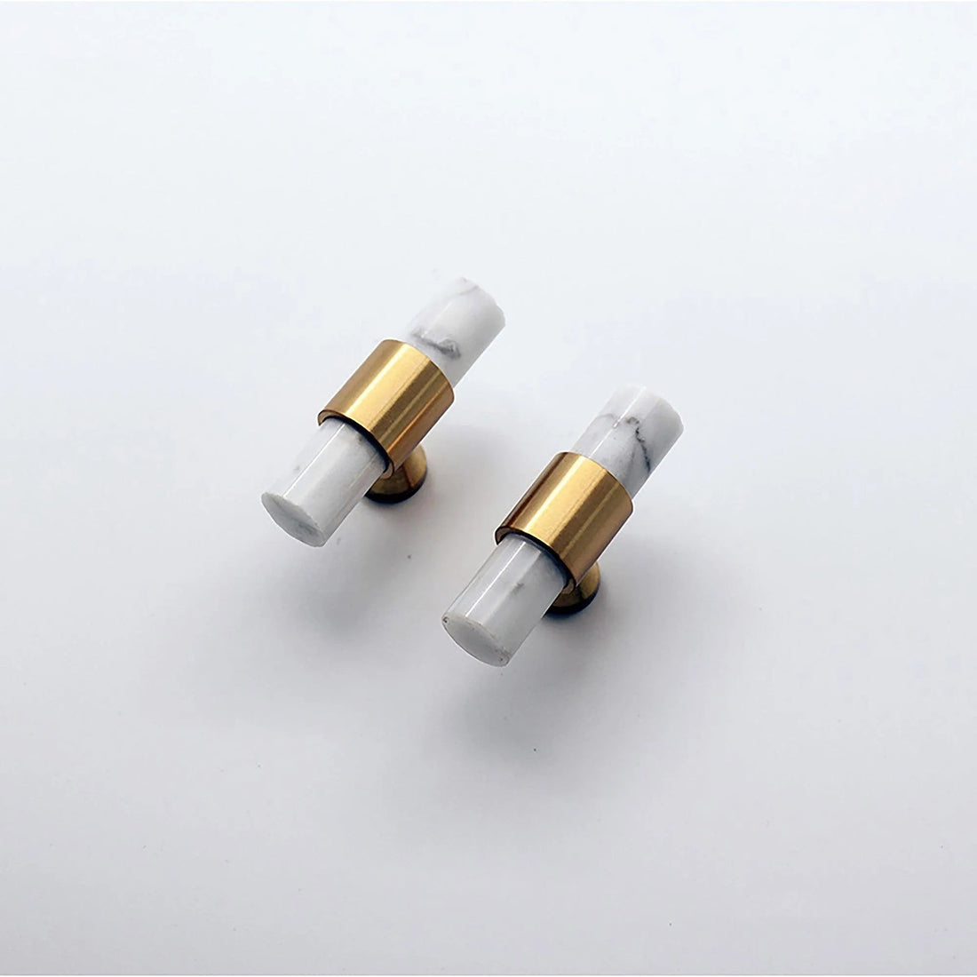 Arabella T Bar Handles in black, gold, white, and gray displayed on a pink background, showcasing modern style by Mantara.