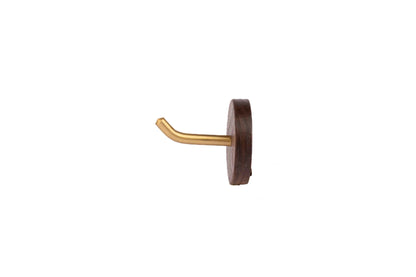 A brown wooden wall hook with a brushed finish, in a circular shape, mounted on a white wall.