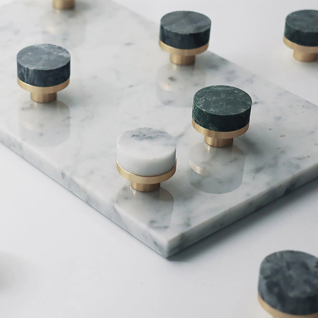 Modern kitchen knob with a brushed finish and white-green marble surface, secured with brass-colored screws by Mantara.