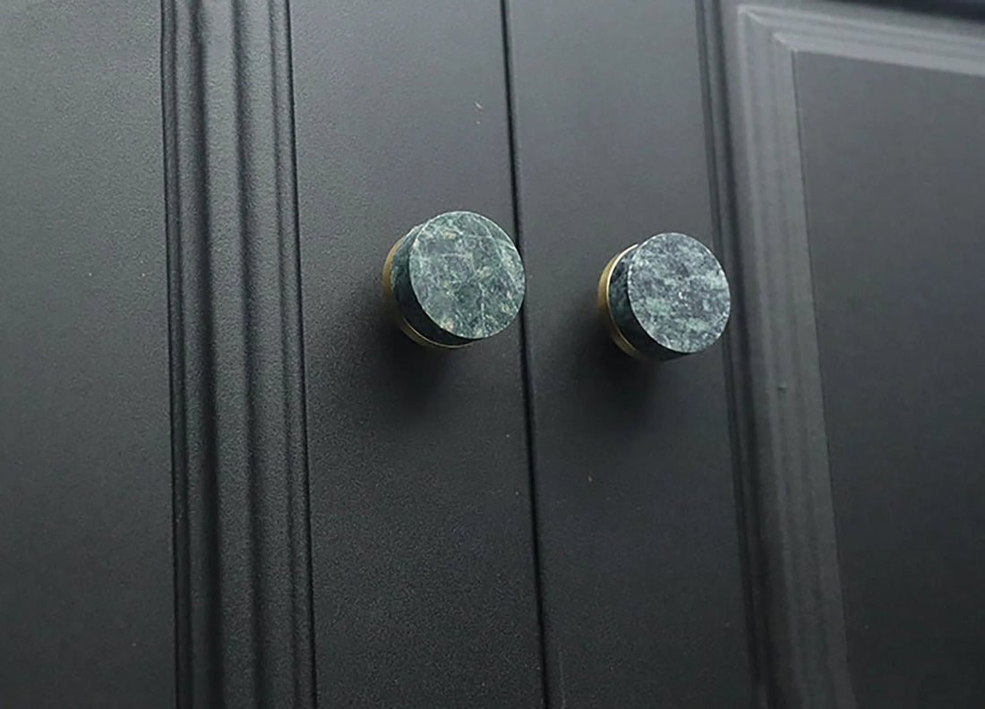 Two black cabinet knobs with green marble accents, highlighting a stylish and modern design detail by Mantara.