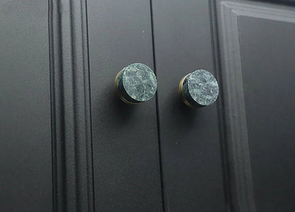 Two black cabinet knobs with green marble accents, highlighting a stylish and modern design detail by Mantara.