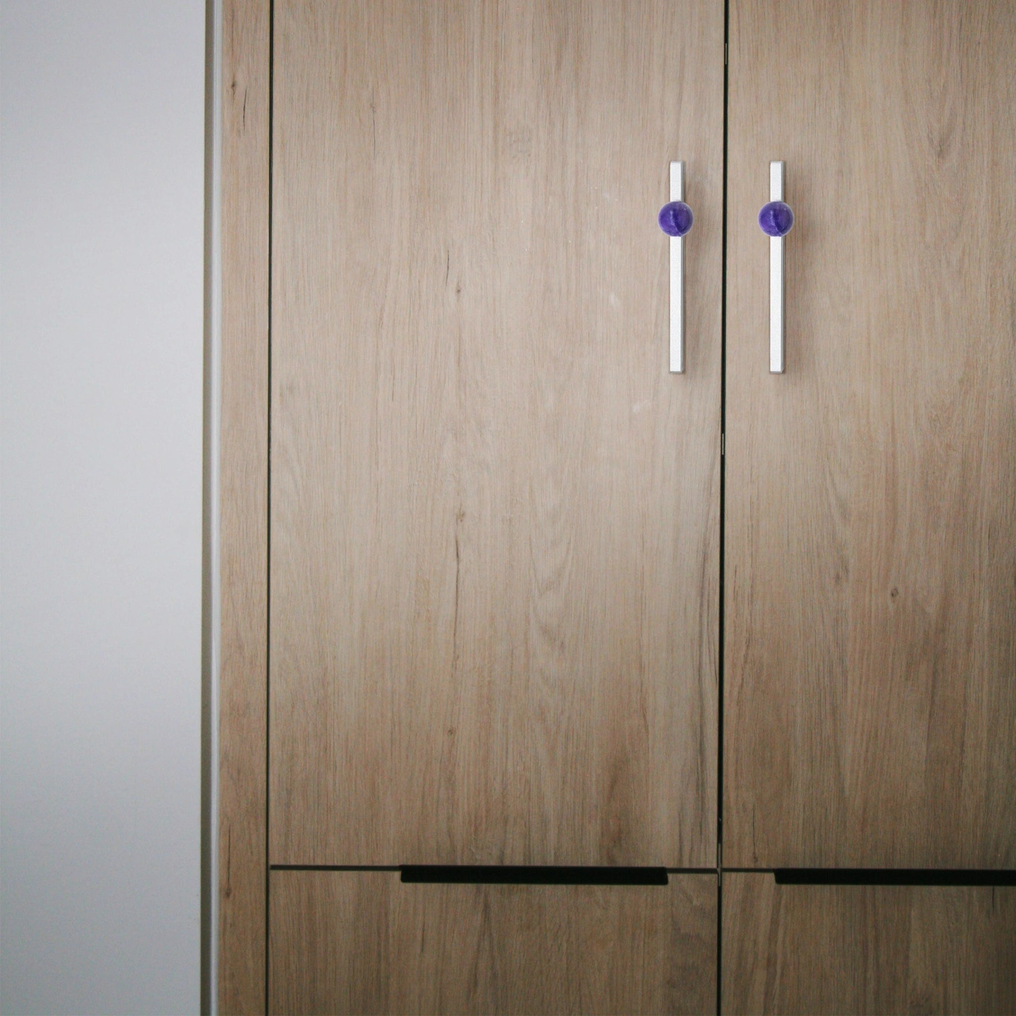 The Mantara C-0027 Calyx Handle is a modern crystal handle in silver and purple, ideal for cabinets, wardrobes, and drawers.