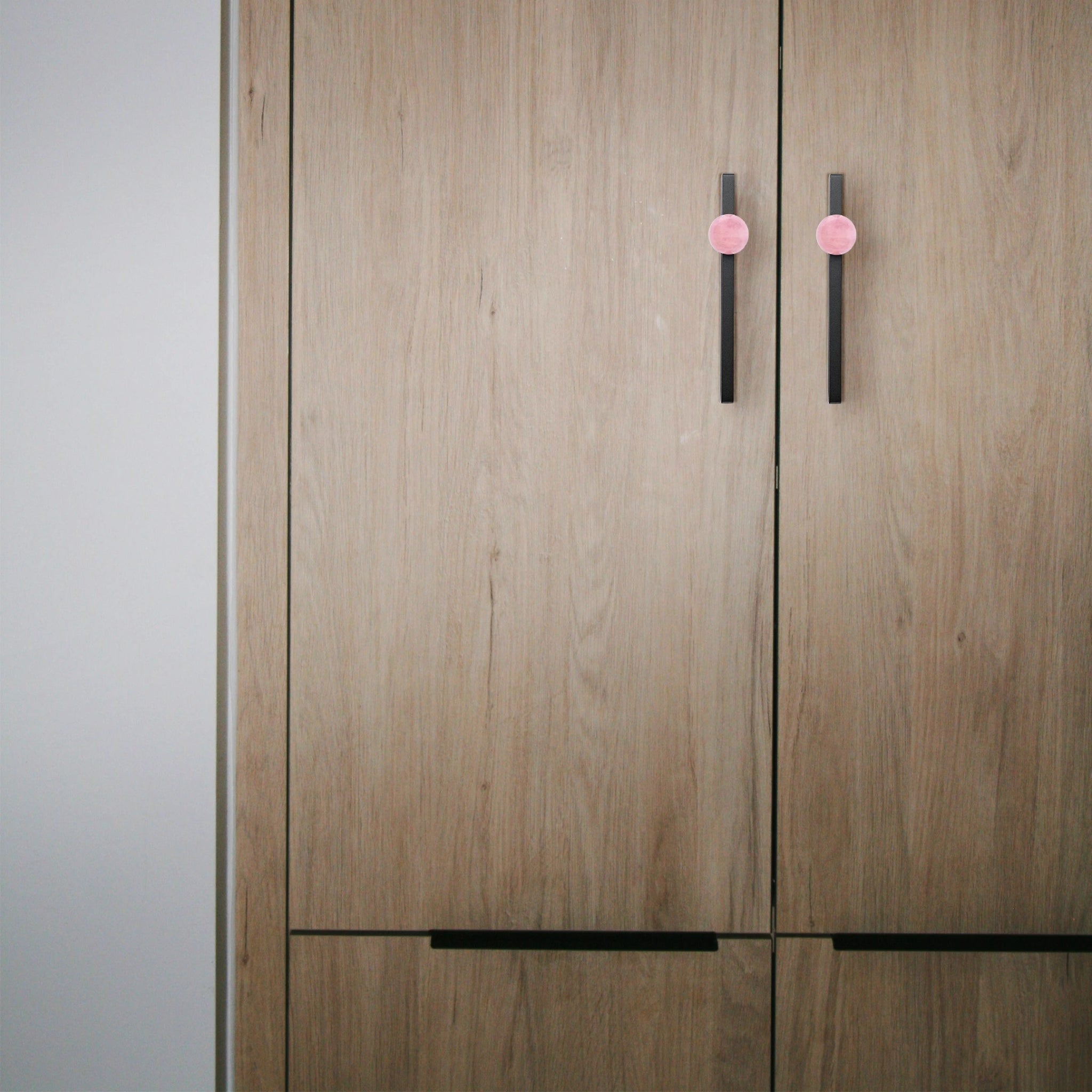 The Mantara C-0027 Calyx Handle is a modern crystal handle in black and pink, ideal for cabinets, wardrobes, and drawers.