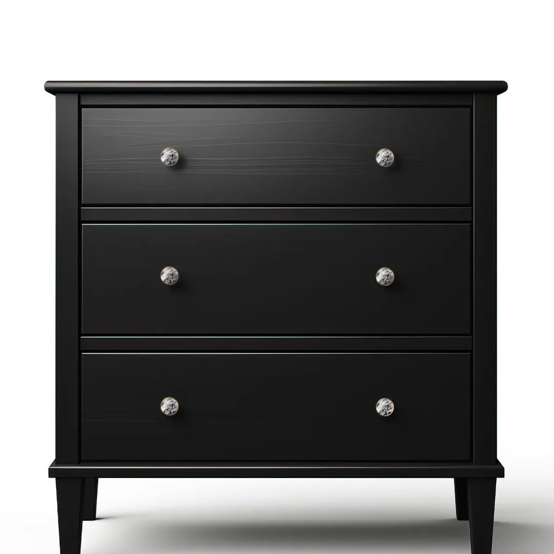A black nightstand with three drawers displayed against a white background, designed by Mantara