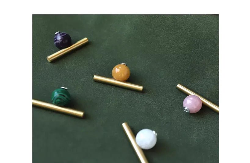 The Mantara C-0020 Chroma T-Bar is a modern crystal and brass knob in pink, purple, green, and white, ideal for drawers and cabinets.