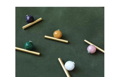 The Mantara C-0020 Chroma T-Bar is a modern crystal and brass knob in pink, purple, green, and white, ideal for drawers and cabinets.