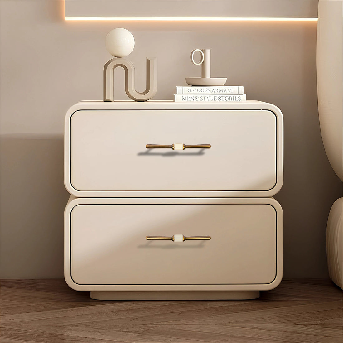 Beige nightstand with two drawers and Bronze handles, styled with decorative items on a wooden floor—by Mantara.