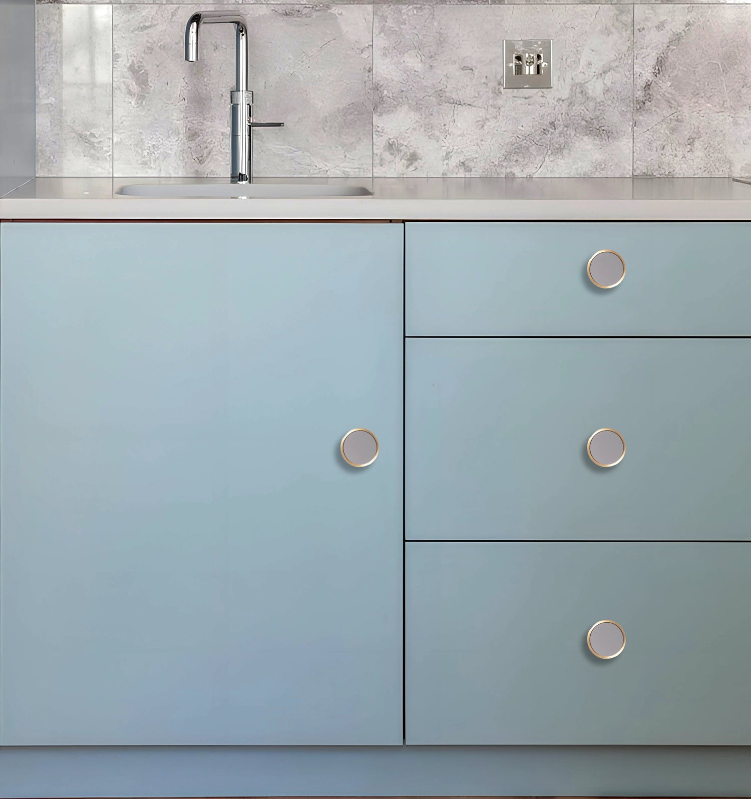 Kitchen cabinet with light blue doors and silver knobs, set against a white marble backsplash, styled by Mantara.