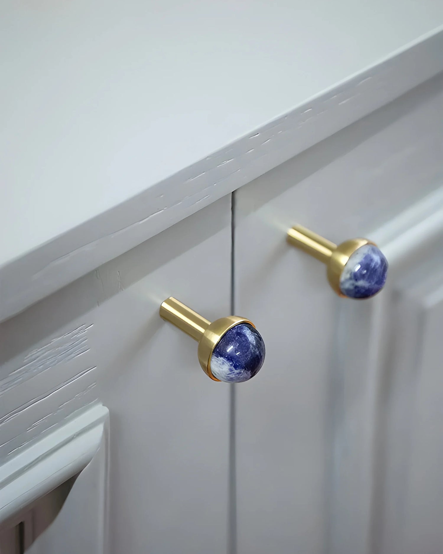 The Mantara C-0006 is a modern crystal + brass knob in blue, ideal for drawers and cabinets.