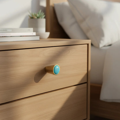 Gold cylindrical object with turquoise stone on a white background