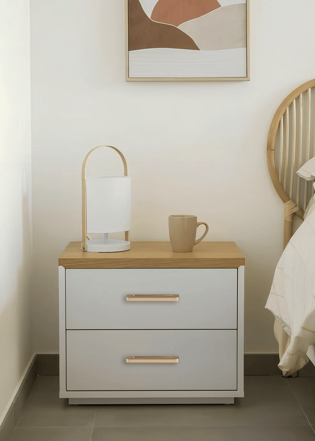 White nightstand with a wooden top and gold handles, styled in a cozy bedroom setting—elegant contrast by Mantara.