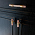 The Mantara C-0014-T Haze Handle is a modern crystal and brass T-handle in pink, ideal for wardrobes and drawers.