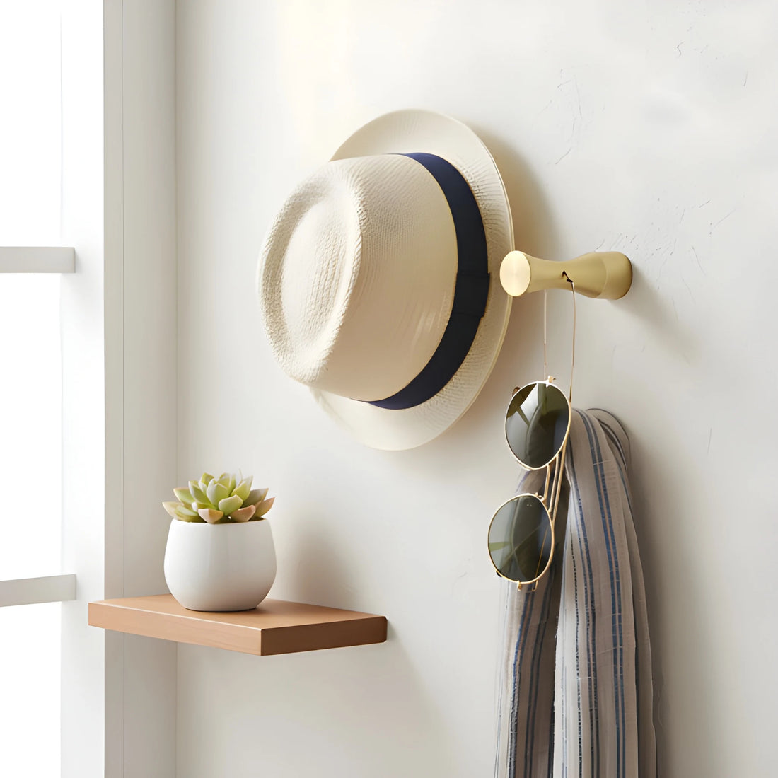 Wall hanger and bathroom hook made of solid brushed brass in polished gold finish by Mantara, model Allegra Hook, B-0096.