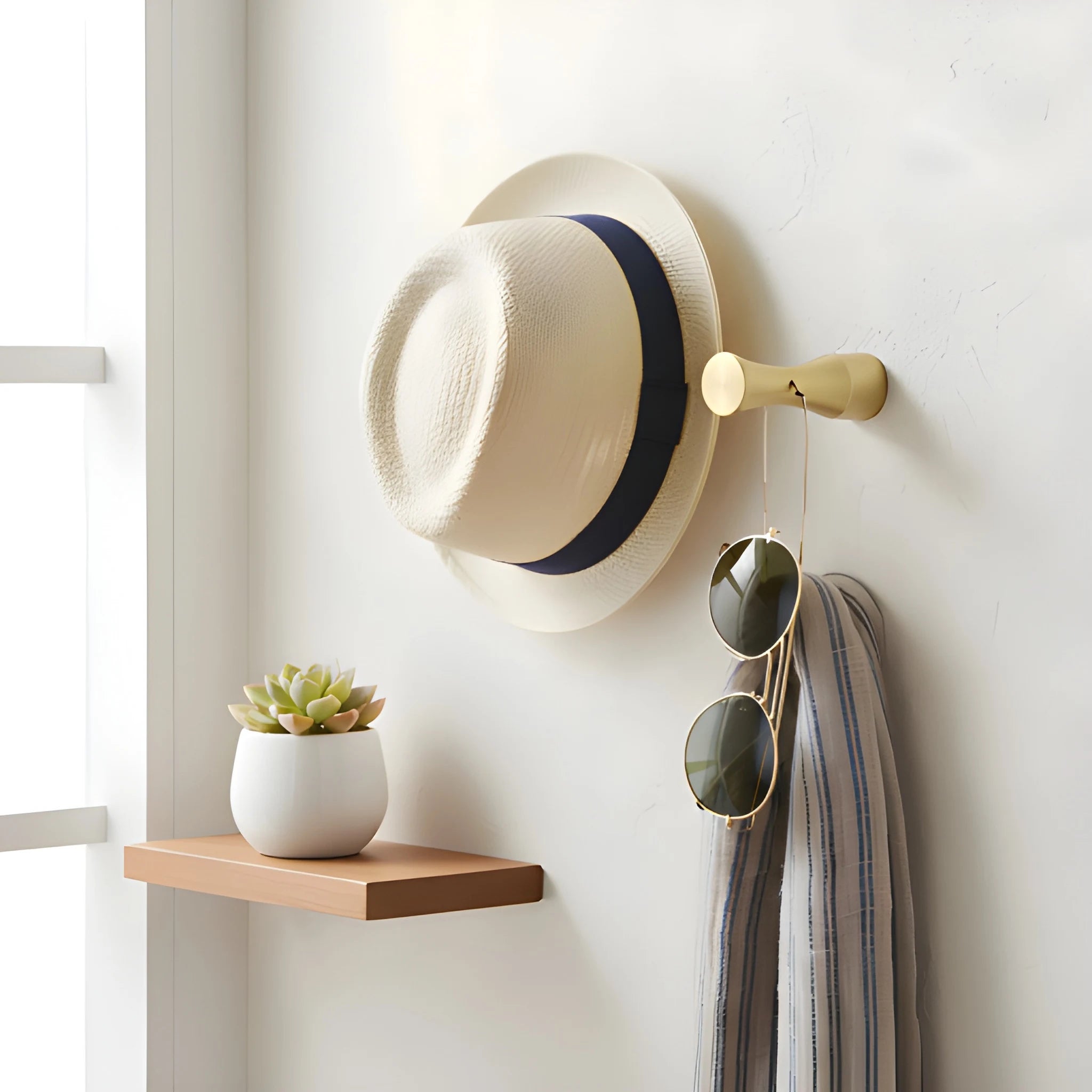 Wall hanger and bathroom hook made of solid brushed brass in polished gold finish by Mantara, model Allegra Hook, B-0096.