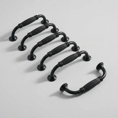 Six black metal cabinet handles arranged diagonally on a light gray background.