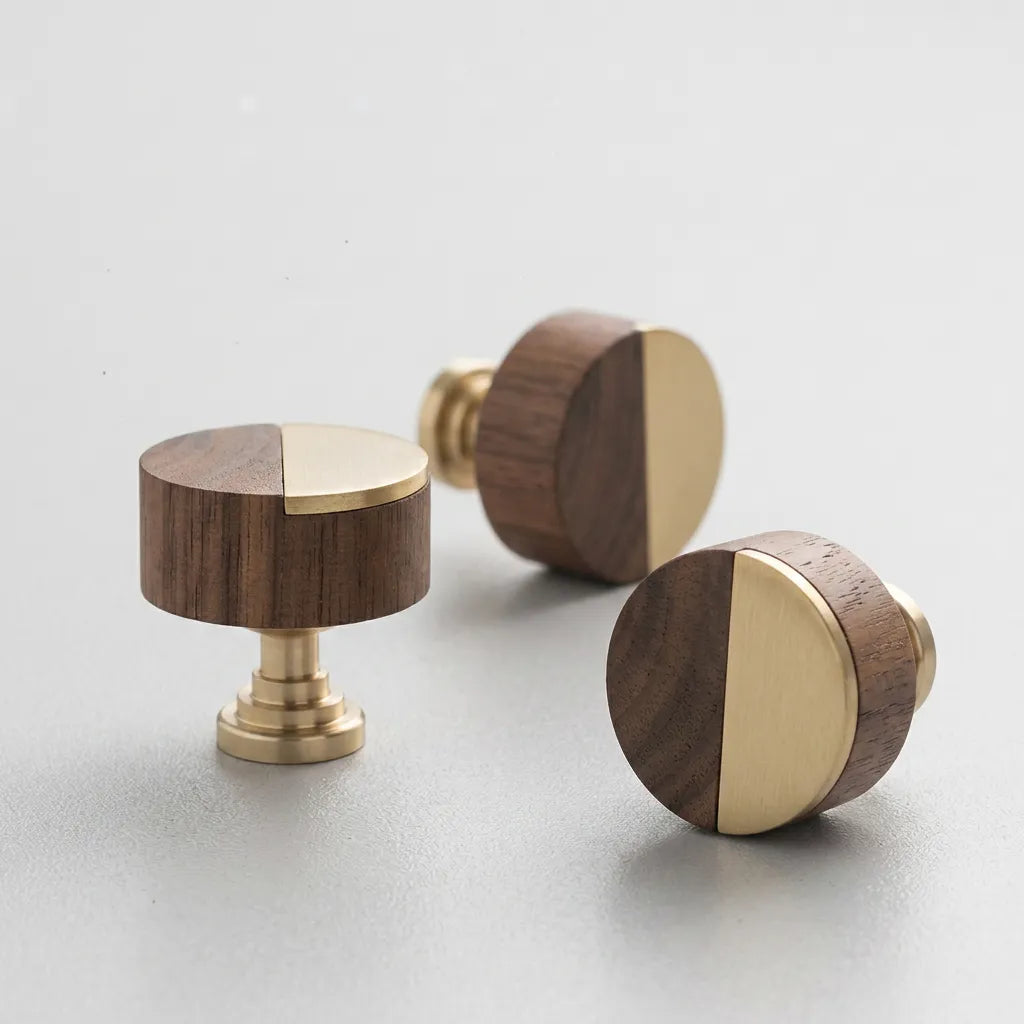 Three round wooden and brass cabinet knobs arranged on a light gray surface, showing both front and side views.