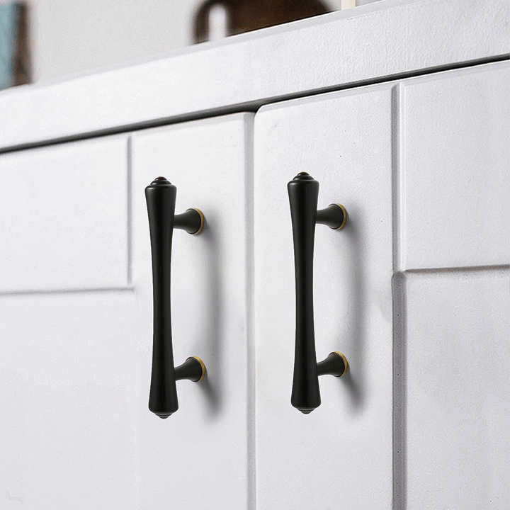 Black cabinet handles mounted on a white cabinet, creating a bold contrast with modern appeal—designed by Mantara.