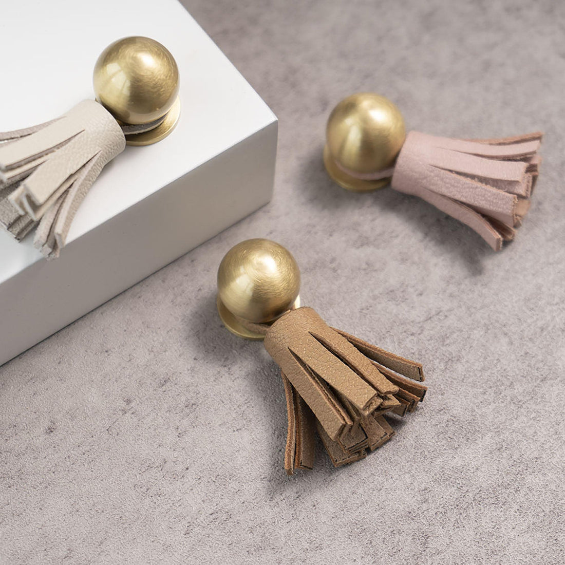 The Mantara L-0002 Maverick Drop Knob is a modern leather and brass knob in white, ideal for kitchens and furniture.