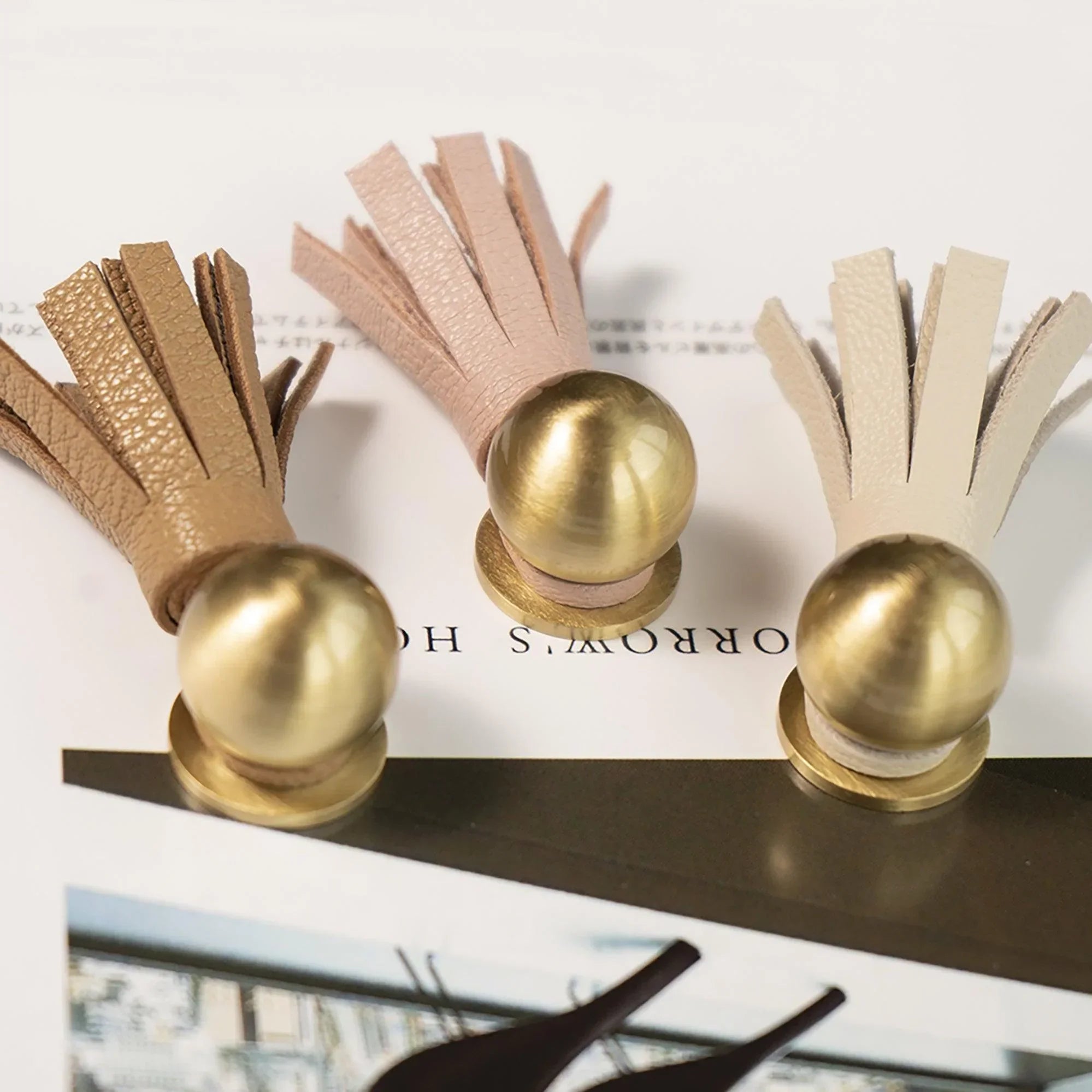 The Mantara L-0002 Maverick Drop Knob is a modern leather and brass knob in white,pink,Brown, ideal for kitchens and furniture.