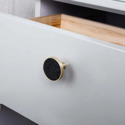 The Mantara L-0004-DIS Obsidian Knob is a modern brass and leather knob in black, ideal for wardrobes, kitchens, and cabinets.