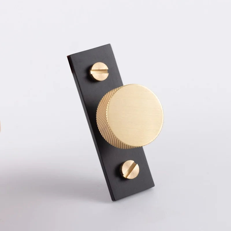 The Mantara B-0118 is a modern brass knob in gold with a black stabiliser base, ideal for kitchen and dresser drawers.