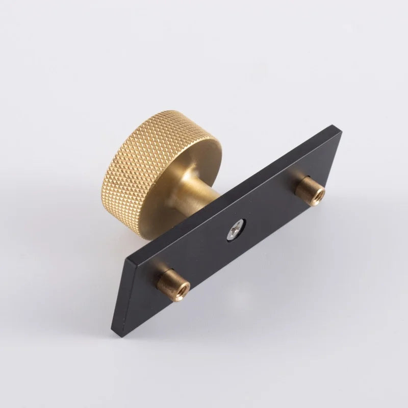 The Mantara B-0118 is a modern brass knob in gold with a black stabiliser base, ideal for kitchen and dresser drawers.