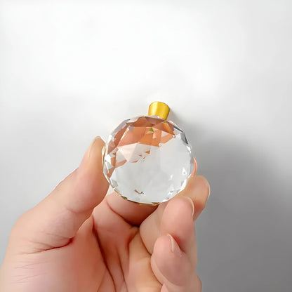The Mantara C-0016 Quartz Handle is a modern crystal knob in white with polished brass, ideal for wardrobes, cabinets, and kitchens.