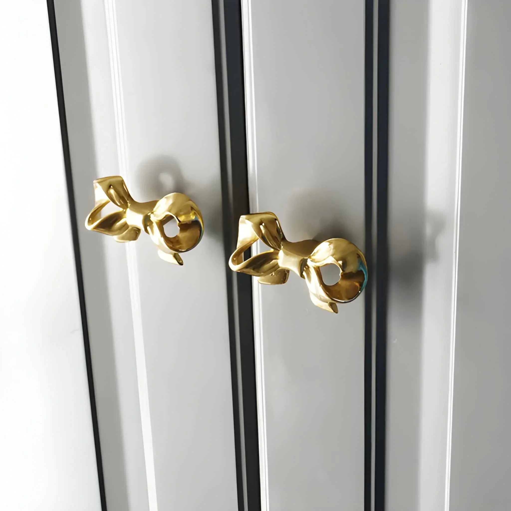 The Mantara B-0020 Ribbon Knob is a modern polished brass knob in gold, perfect for wardrobes, kitchens, drawers, and cabinets.