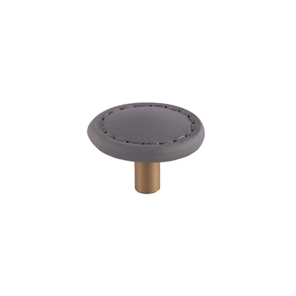 The Mantara L-0008 Sofia Round Knob is a modern leather knob in grey, ideal for cabinets and wardrobes.