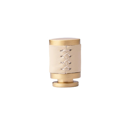 The Mantara L-0003 Tanner Knob is a modern brass and leather knob in white, perfect for cabinets and furniture.