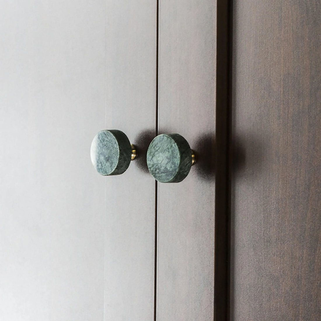 The Mantara M-0001 Theo Knob is a modern marble and brass knob in green, ideal for doors, drawers, and cabinets.