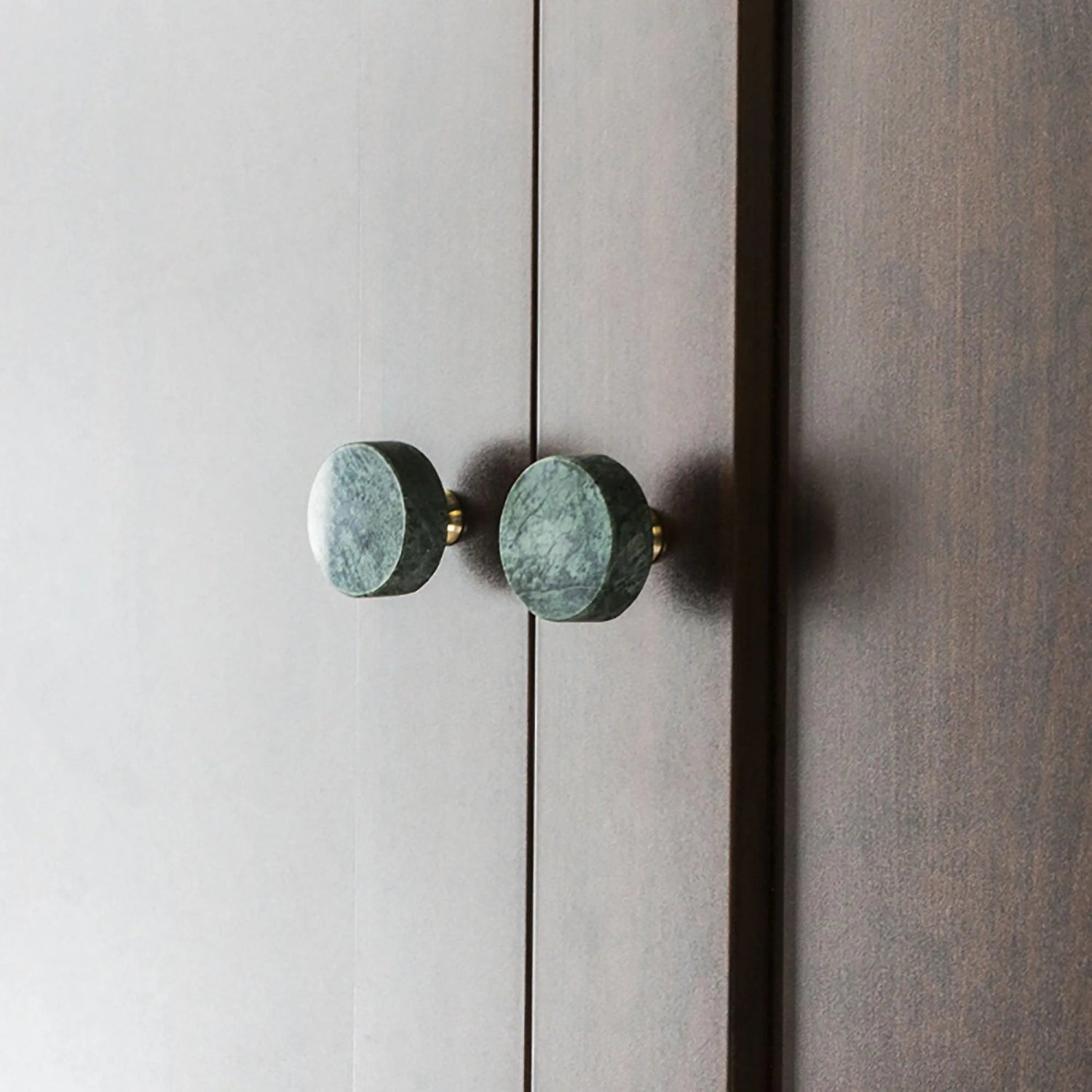 The Mantara M-0001 Theo Knob is a modern marble and brass knob in green, ideal for doors, drawers, and cabinets.