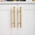 The Zania Handle by Mantara B-0111 is a modern brushed brass handle in gold, ideal for kitchens, dressers, and cabinets.