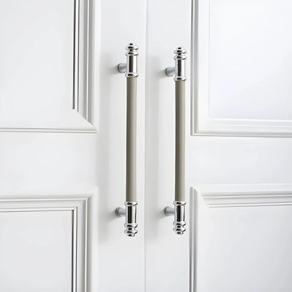 The Mantara L-0013 is a modern brass + leather handle in grey, ideal for kitchen drawers, dressers, and cabinets.